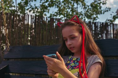 Küçük kız çocuk, başında kedi kulakları şeklinde bir jant, portre. Moda kırmızı saçlı kız.