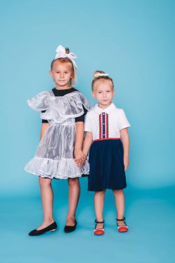 Okula geri dön. Mavi arka planda iki kız öğrenci