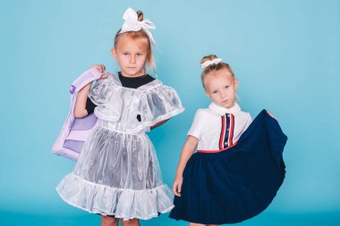 Okula geri dön. Mavi arka planda iki kız öğrenci