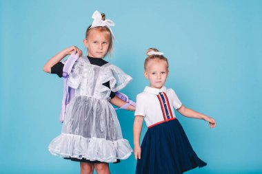 Okula geri dön. Mavi arka planda iki kız öğrenci