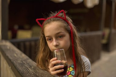 küçük kız kahverengi bir içki içiyor