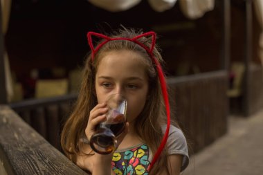 küçük kız kahverengi bir içki içiyor