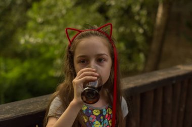 küçük kız kahverengi bir içki içiyor