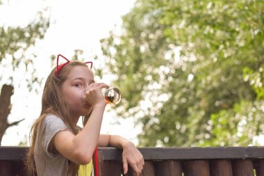 küçük kız kahverengi bir içki içiyor