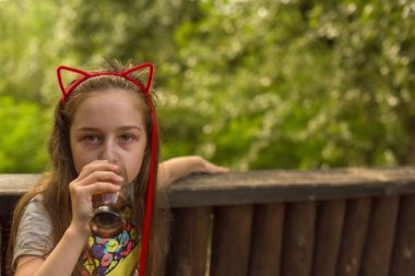 küçük kız kahverengi bir içki içiyor