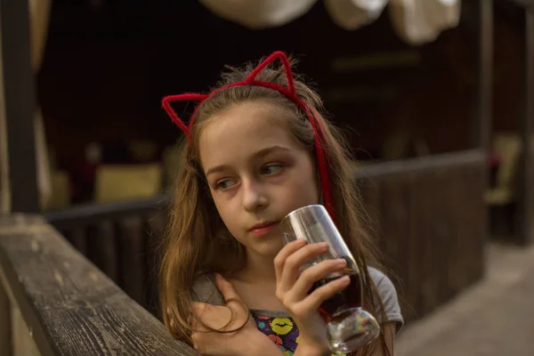 Kleines Mädchen trinkt ein braunes Getränk — Stockfoto