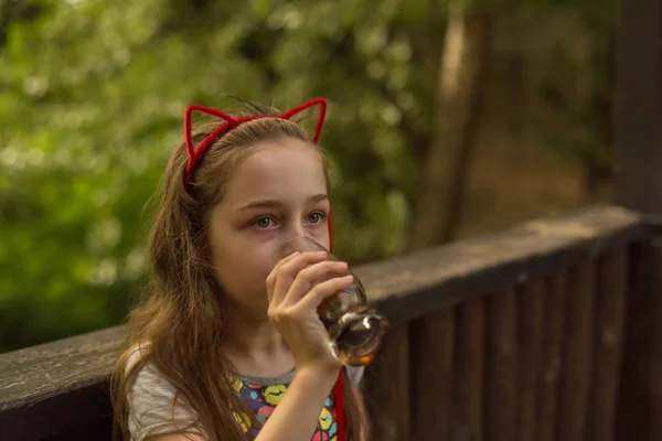 Маленькая девочка пьет коричневый напиток — стоковое фото