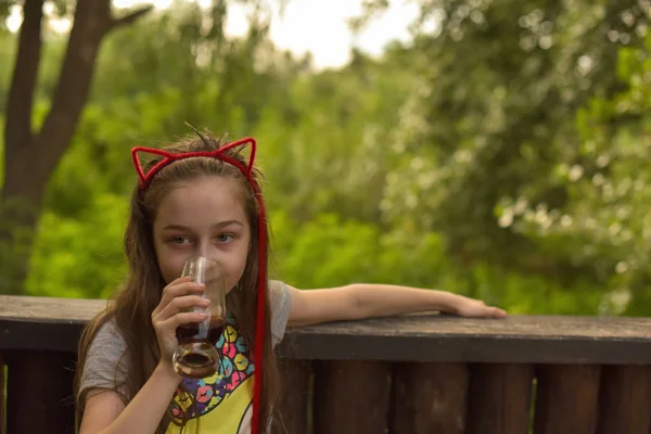 小さな女の子は茶色の飲み物を飲む — ストック写真