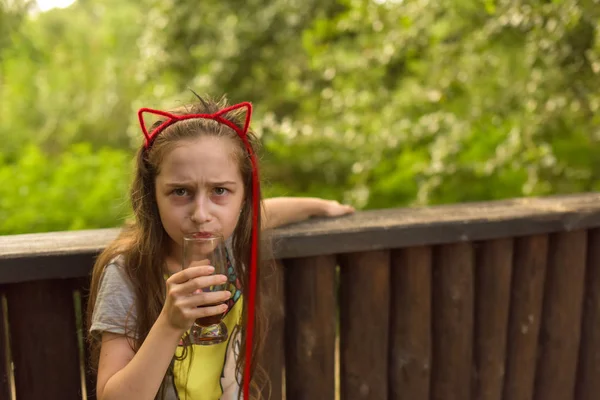 小さな女の子は茶色の飲み物を飲む — ストック写真