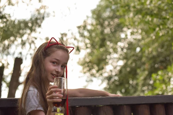 小さな女の子は茶色の飲み物を飲む — ストック写真
