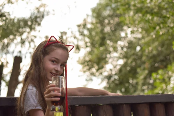 Kleines Mädchen trinkt ein braunes Getränk — Stockfoto