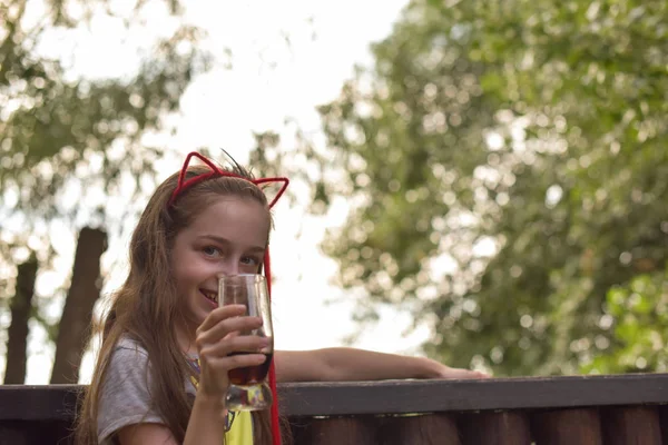 Kleines Mädchen trinkt ein braunes Getränk — Stockfoto