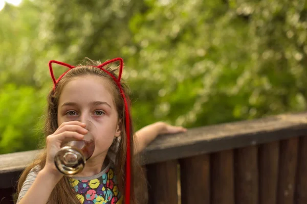 Маленькая девочка пьет коричневый напиток — стоковое фото