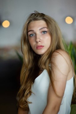 Mavi gözlü bir kız şehir kafede oturuyor. kahverengi dalgalı saç modeli ile kadın. Yaşam tarzı kavramı.