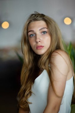 Mavi gözlü bir kız şehir kafede oturuyor. kahverengi dalgalı saç modeli ile kadın. Yaşam tarzı kavramı.