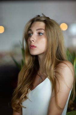 Mavi gözlü bir kız şehir kafede oturuyor. kahverengi dalgalı saç modeli ile kadın. Yaşam tarzı kavramı.