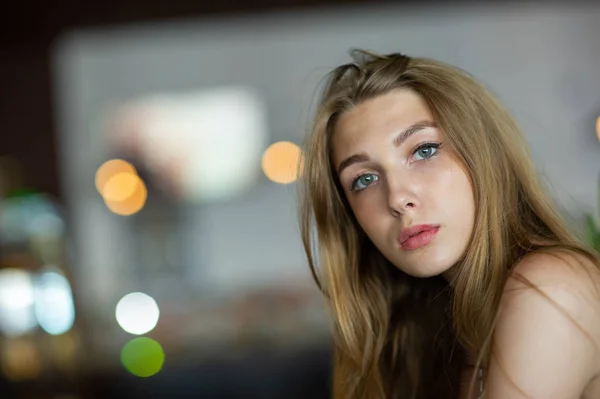 Chica con ojos azules sentada en la cafetería urbana. mujer con peinado ondulado marrón. Concepto de estilo de vida . — Foto de Stock