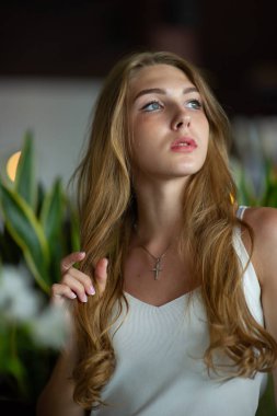 Mavi gözlü bir kız şehir kafede oturuyor. kahverengi dalgalı saç modeli ile kadın. Yaşam tarzı kavramı.