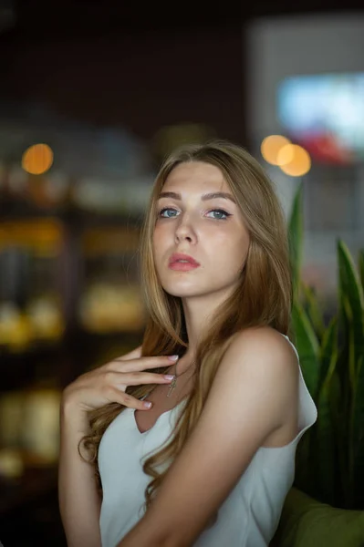 Chica con ojos azules sentada en la cafetería urbana. mujer con peinado ondulado marrón. Concepto de estilo de vida . —  Fotos de Stock