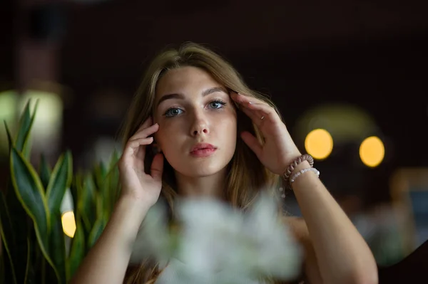 Mädchen mit blauen Augen, die auf einem städtischen Café sitzen. Frau mit brauner welliger Frisur. Lifestylekonzept. — Stockfoto