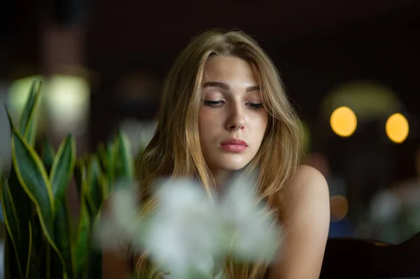 Mädchen mit blauen Augen, die auf einem städtischen Café sitzen. Frau mit brauner welliger Frisur. Lifestylekonzept. — Stockfoto