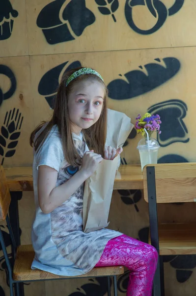 Niña sosteniendo una bolsa de papel con comida en las manos — Foto de Stock