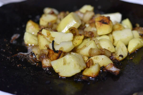 Cooking fried potatoes in outdoor conditions on fire. Fire fried potatoes — Stock Photo, Image