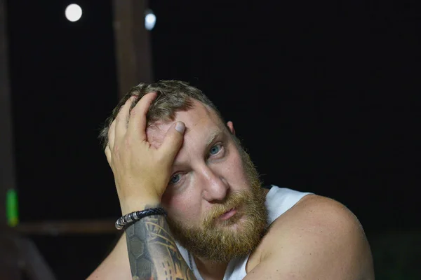 Red bearded hipster in summer time. A man with a red beard in a white shirt