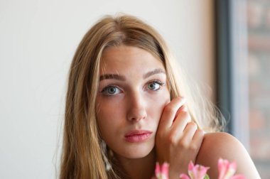 Mavi gözlü bir kız şehir kafede oturuyor. kahverengi dalgalı saç modeli ile kadın. Yaşam tarzı kavramı.