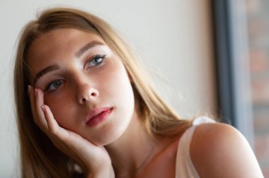 Mavi gözlü bir kız şehir kafede oturuyor. kahverengi dalgalı saç modeli ile kadın. Yaşam tarzı kavramı.