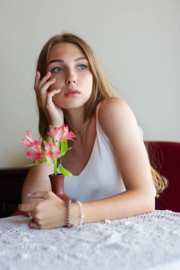 Mavi gözlü bir kız şehir kafede oturuyor. kahverengi dalgalı saç modeli ile kadın. Yaşam tarzı kavramı.