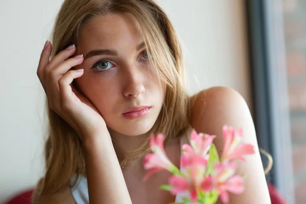 Mädchen mit blauen Augen, die auf einem städtischen Café sitzen. Frau mit brauner welliger Frisur. Lifestylekonzept. — Stockfoto