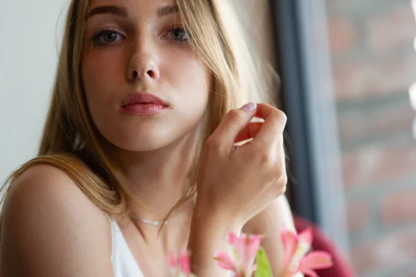 Chica con ojos azules sentada en la cafetería urbana. mujer con peinado ondulado marrón. Concepto de estilo de vida . — Foto de Stock