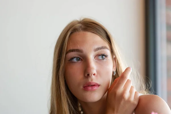 Chica con ojos azules sentada en la cafetería urbana. mujer con peinado ondulado marrón. Concepto de estilo de vida . — Foto de Stock