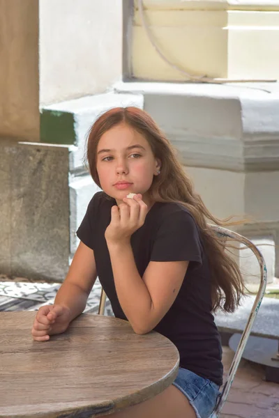 Menina bonita comendo doces de coco — Fotografia de Stock