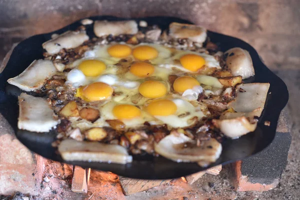 Vejce jsou smaženými na ohni na ulici. Smažená vejce se slaninou. — Stock fotografie