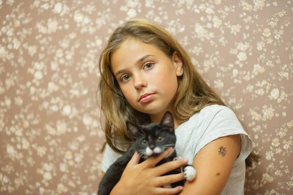 Fille 10 ans et un chaton noir et blanc . — Photo