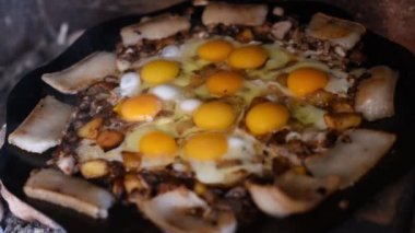 Yumurtalar sokakta ateşte kızarır. Pastırmalı sahanda yumurta. Fırındaki şenlik ateşinde bir tabak yumurta. Tahıl yağı. Sokak yemeği. Yiyeceklerle dinlen. Tavada ızgara yumurta.