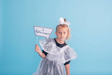 Güzel genç birinci sınıf öğrencisinin portresi. Çiçeklerle stüdyoda birinci sınıf öğrencisi kız