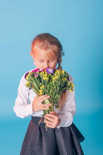 美しい若い小学1年生の肖像画。花とスタジオの1年生の女の子 — ストック写真