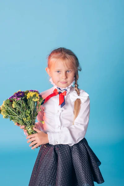 美しい若い小学1年生の肖像画。花とスタジオの1年生の女の子 — ストック写真