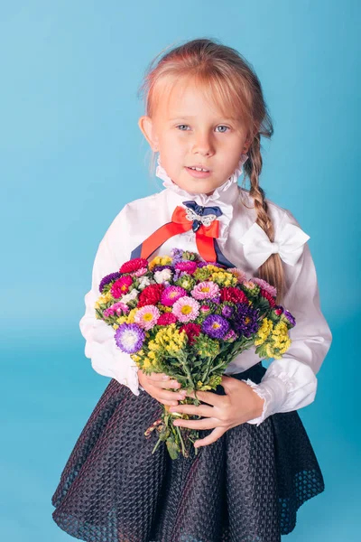 美しい若い小学1年生の肖像画。花とスタジオの1年生の女の子 — ストック写真