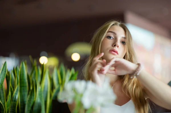 Chica con ojos azules sentada en la cafetería urbana. mujer con peinado ondulado marrón. Concepto de estilo de vida . — Foto de Stock