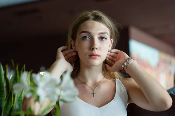 Chica con ojos azules sentada en la cafetería urbana. mujer con peinado ondulado marrón. Concepto de estilo de vida . —  Fotos de Stock