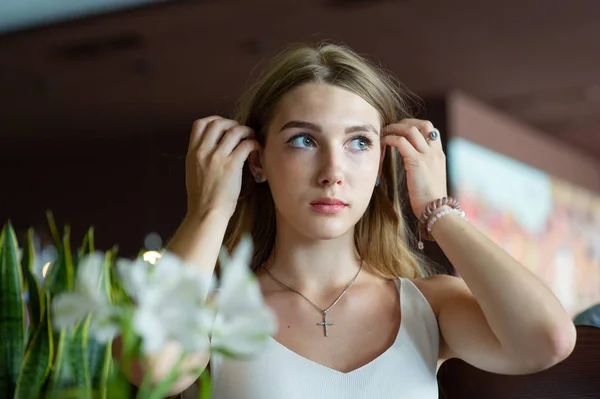 Chica con ojos azules sentada en la cafetería urbana. mujer con peinado ondulado marrón. Concepto de estilo de vida . — Foto de Stock