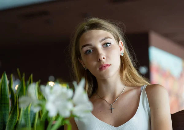 Chica con ojos azules sentada en la cafetería urbana. mujer con peinado ondulado marrón. Concepto de estilo de vida . — Foto de Stock