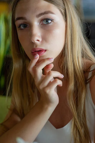 Chica con ojos azules sentada en la cafetería urbana. mujer con peinado ondulado marrón. Concepto de estilo de vida . — Foto de Stock