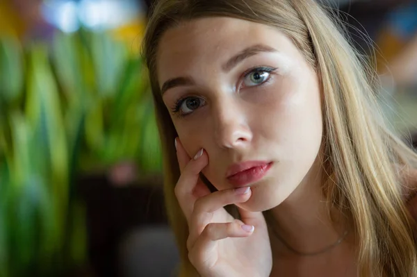 Mädchen mit blauen Augen, die auf einem städtischen Café sitzen. Frau mit brauner welliger Frisur. Lifestylekonzept. — Stockfoto