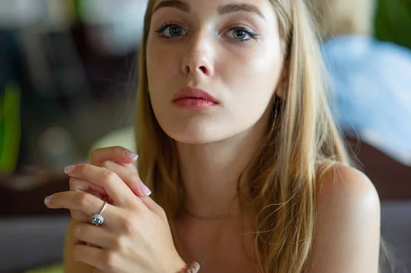 蓝眼睛的女孩坐在城市咖啡馆。女人与棕色波浪发型。生活方式理念. — 图库照片