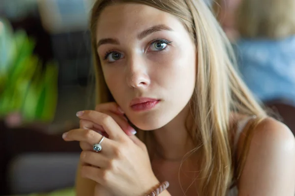 Fille aux yeux bleus assise sur un café urbain. femme avec une coiffure ondulée brune. Concept de style de vie . — Photo